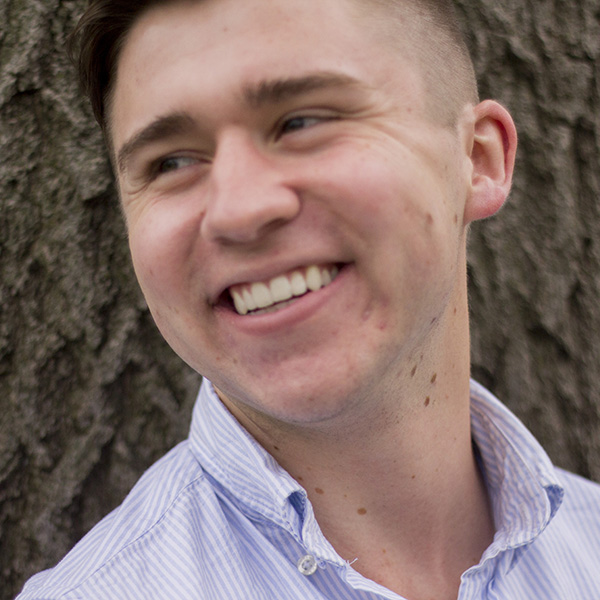 Daniel Parnell smiles in front of a tree